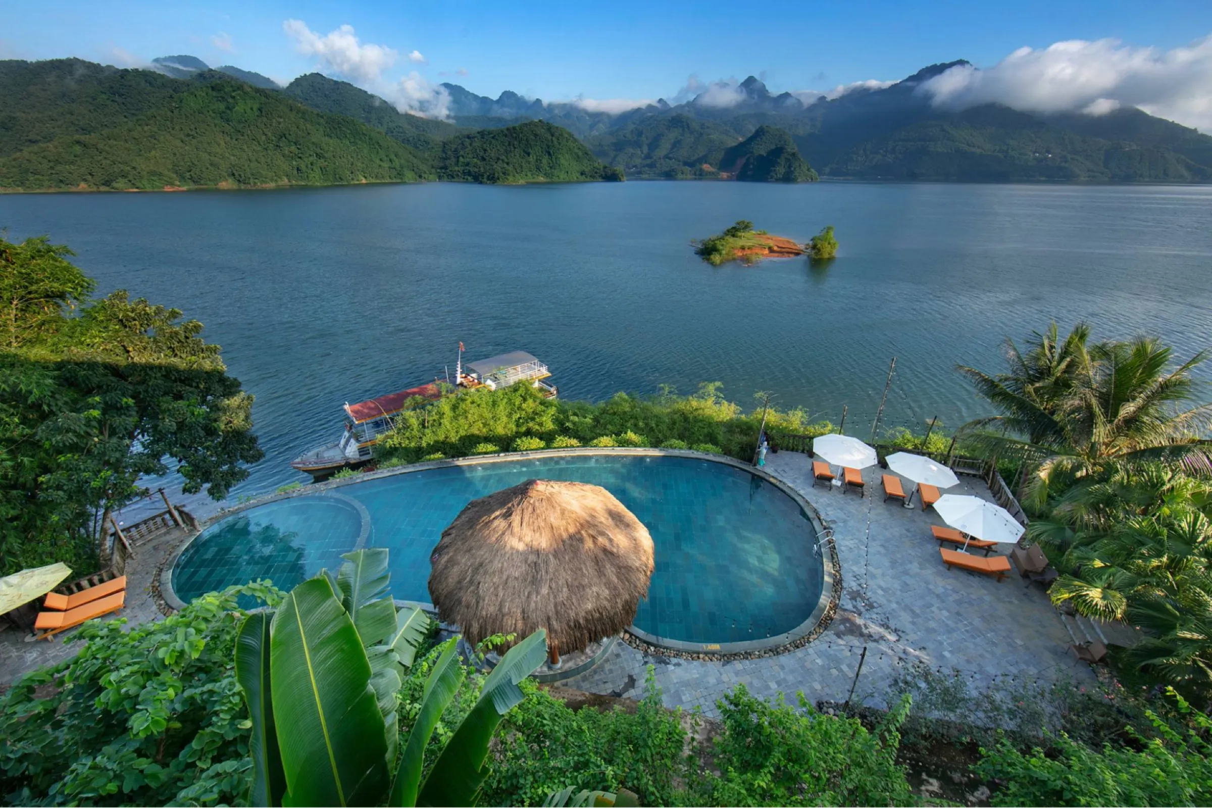 An infinity pool on the edge of the lake at the Mai Chau Hideaway, mountains beyond.