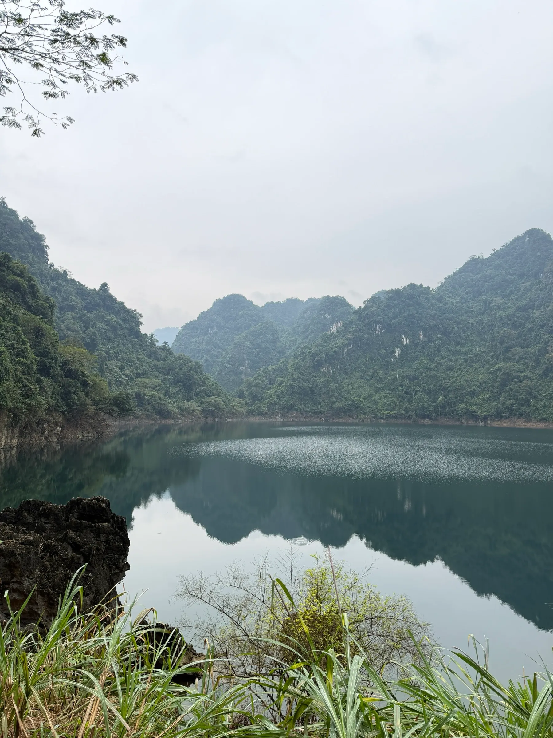 Still water and limestone hills mirrored on a quiet stretch of the lake.