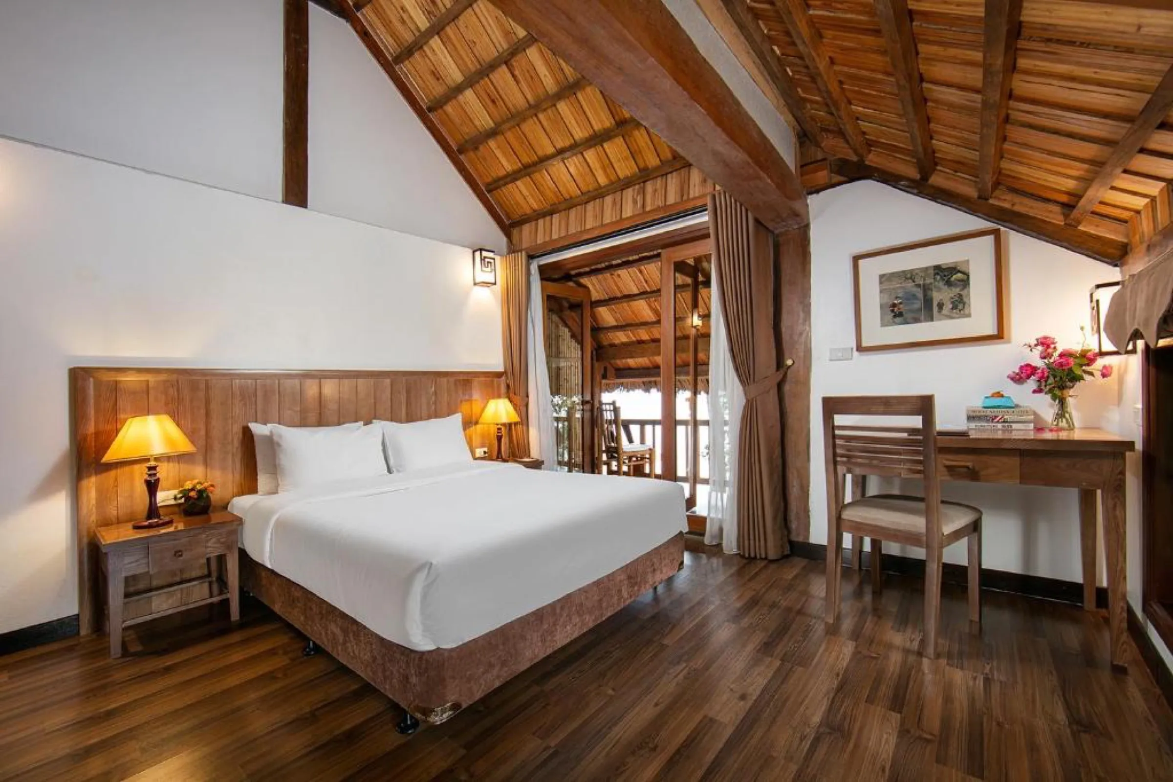 A double room with a wooden ceiling and a private balcony at the Mai Chau Hideaway.